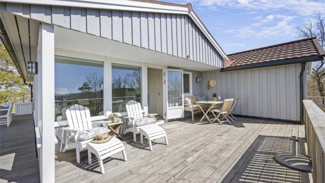 Fasaden er kledd med stående trekledning, og taket har takplater fra 2021 på tilbygget.