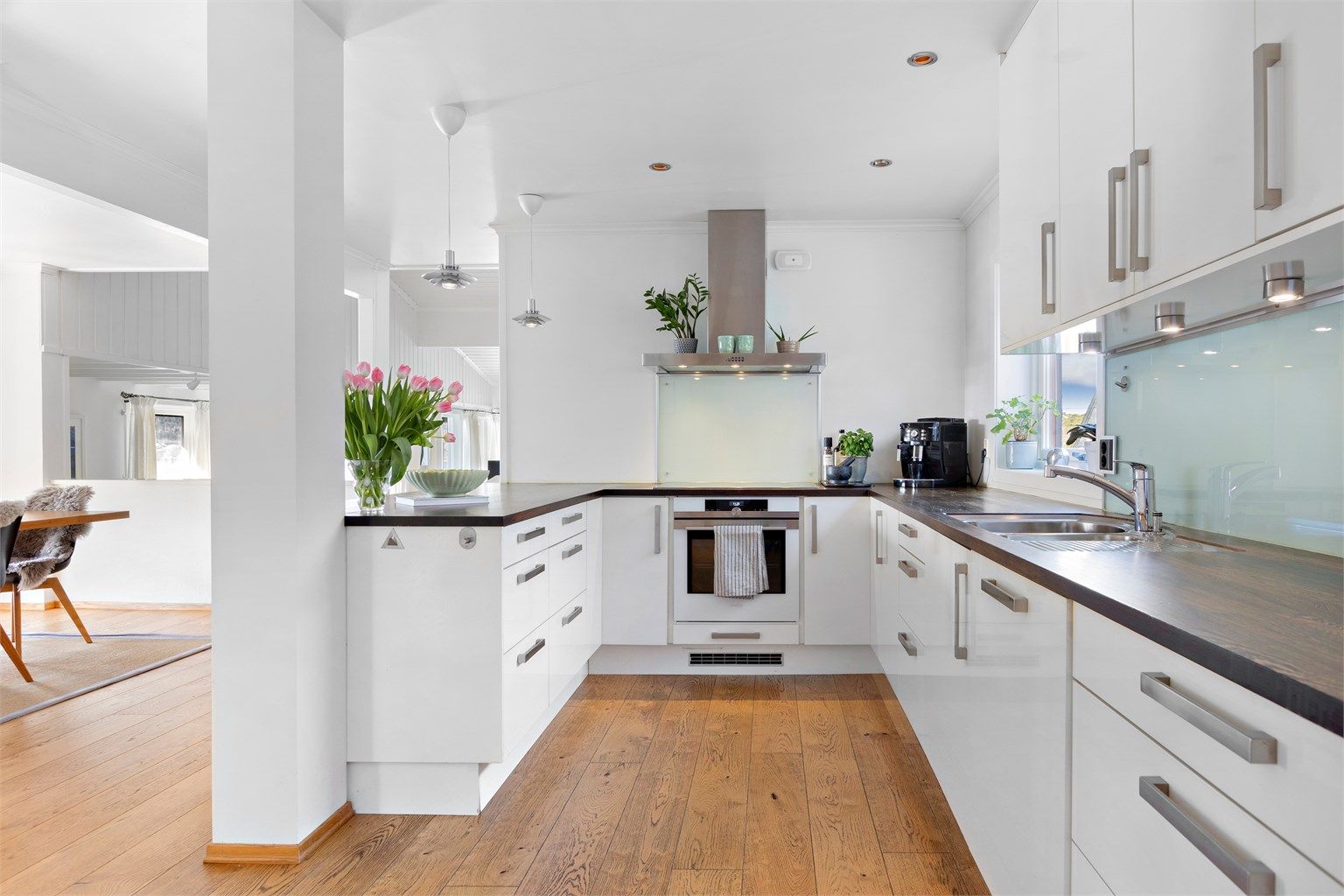 Kjøkkeninnredning fra Norema (2008) med hvite, slette fronter og heltre benkeplate.