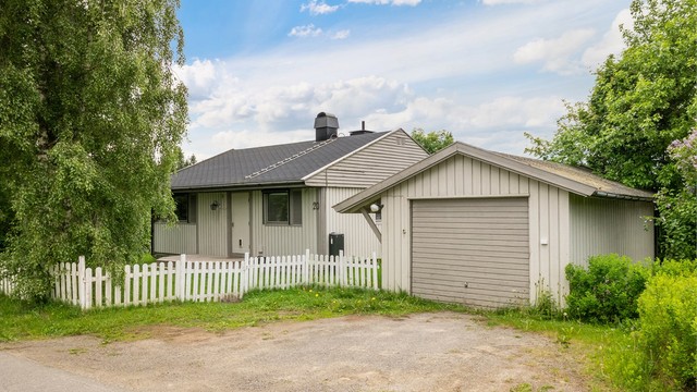 Garasje med el-billader montert på yttervegg mot huset.