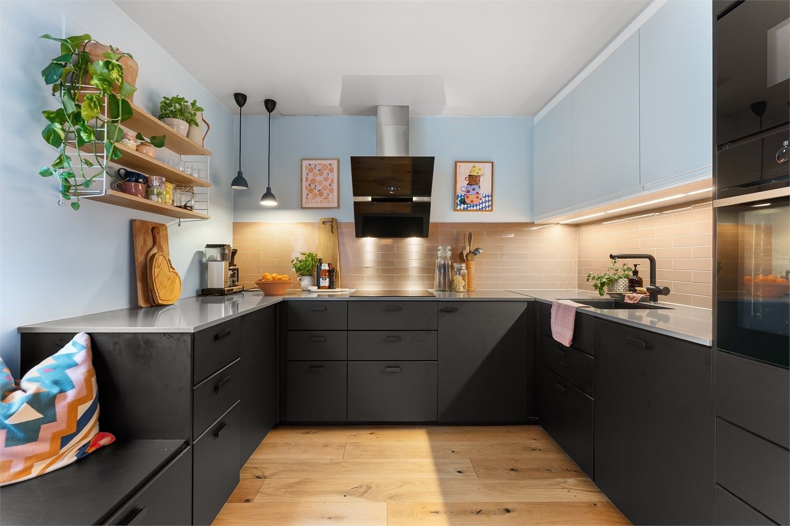 Stilrent og innholdsrikt kjøkken med rikelig skap- og benkeplass.