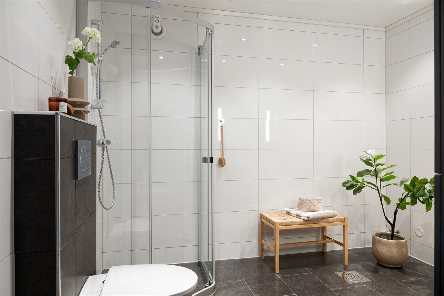 Badet er innredet med vask, dusjnisje og vegghengt toalett. 