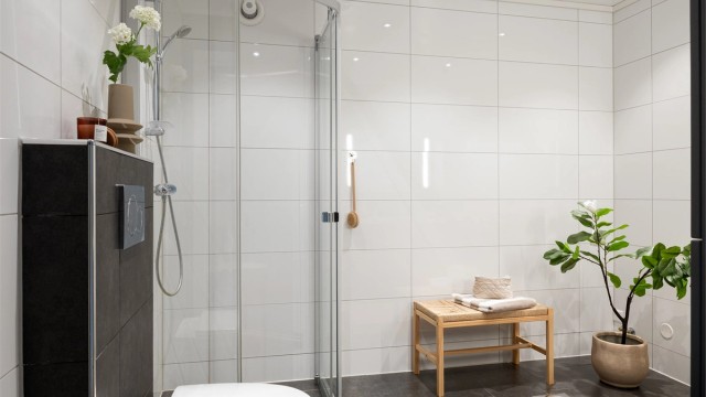 Badet er innredet med vask, dusjnisje og vegghengt toalett.