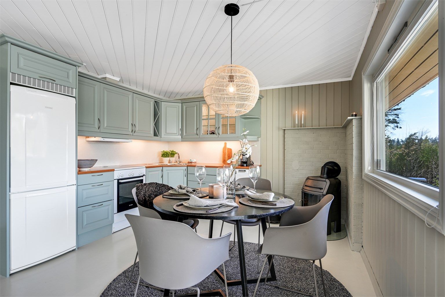 Koselig kjøkken med malte, profilerte fronter og en benkeplate i laminat. kjøkkenventilatoren har avtrekk ut. Det er plass til frittstående kjøl/fryseskap, oppvaskmaskin og komfyr.