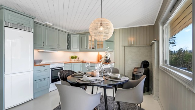 Koselig kjøkken med malte, profilerte fronter og en benkeplate i laminat. kjøkkenventilatoren har avtrekk ut. Det er plass til frittstående kjøl/fryseskap, oppvaskmaskin og komfyr.