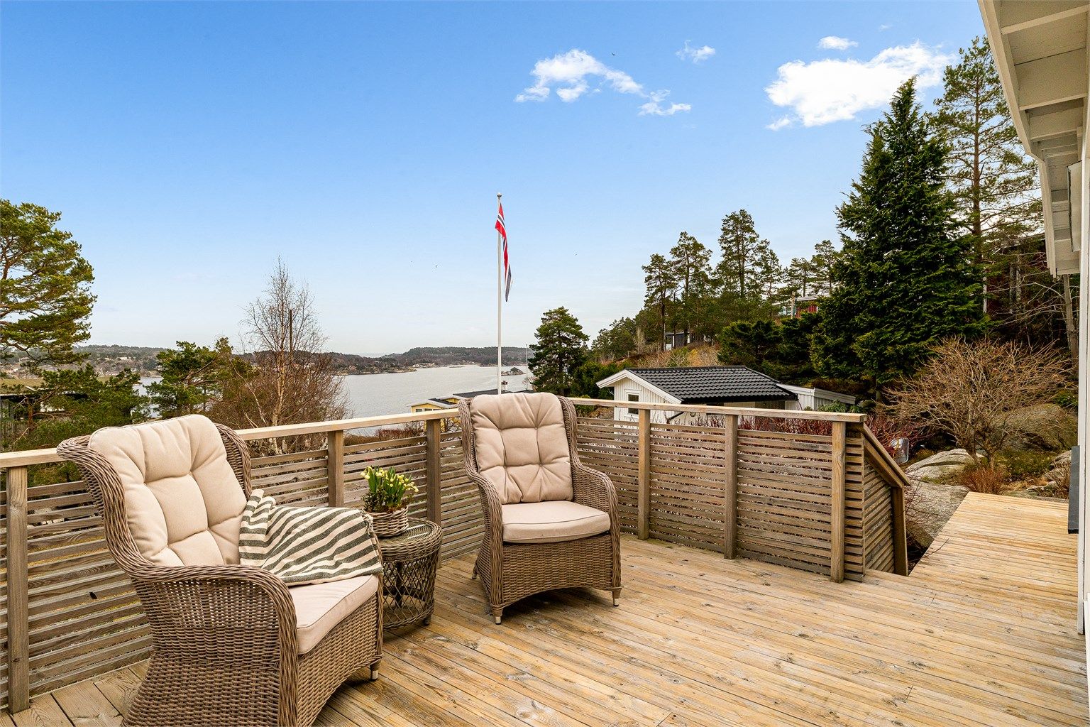 Hytta ligger høyt og fritt til på tomten. Mot øst, med utgang fra spisestuen, har du en solrik terrasse som vender mot sjøen. En perfekt plass for å nyte morgenkaffen og utsikten.