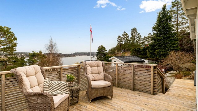 Hytta ligger høyt og fritt til på tomten. Mot øst, med utgang fra spisestuen, har du en solrik terrasse som vender mot sjøen. En perfekt plass for å nyte morgenkaffen og utsikten.