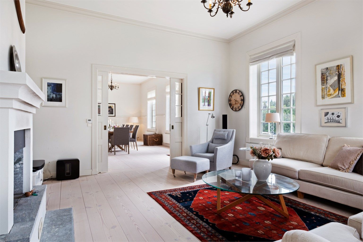 En tofløyet dør skiller stuen fra spisestuen, og skaper en elegant overgang mellom sonene