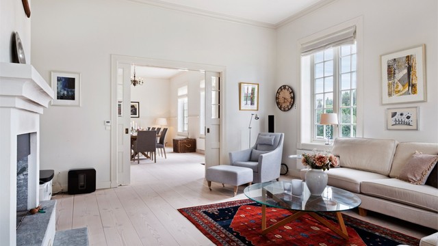 En tofløyet dør skiller stuen fra spisestuen, og skaper en elegant overgang mellom sonene