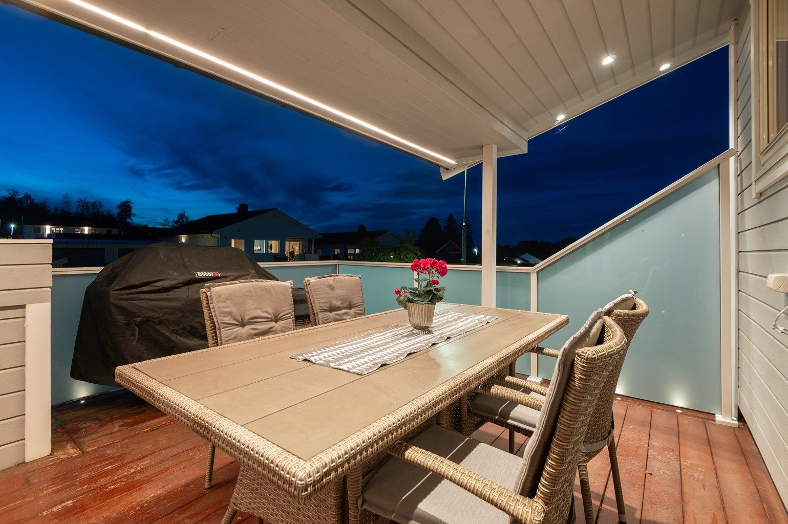 Veranda mot vest, med overbygg og belysning. 