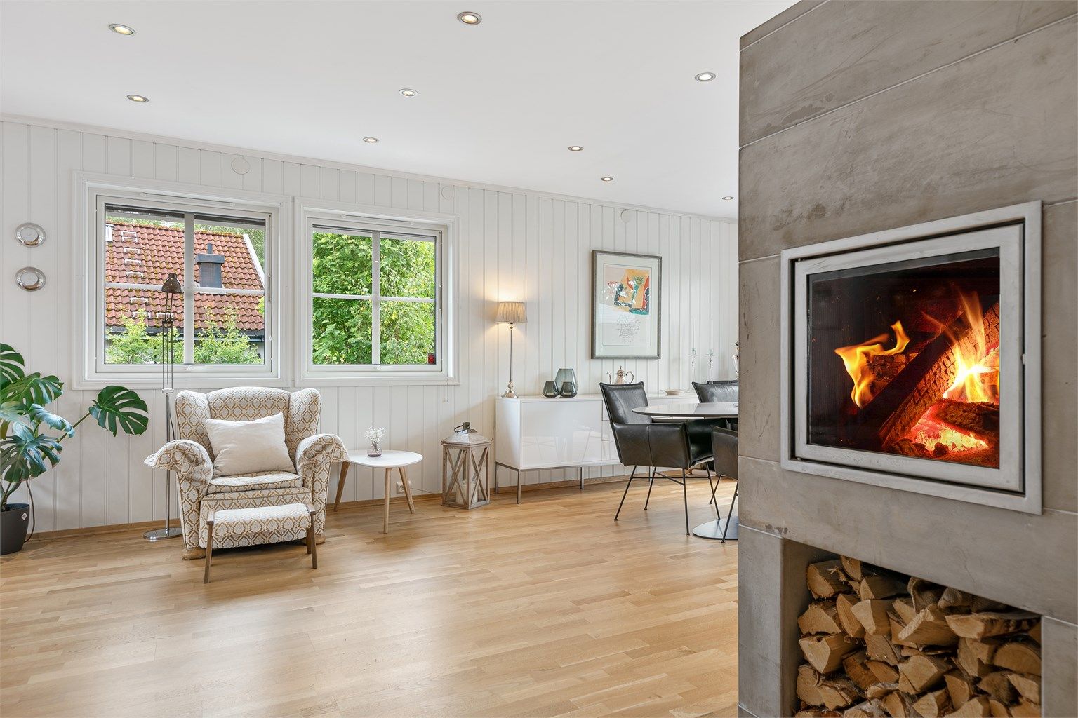 Peisen er strategisk plassert midt i rommet og bidrar med varme og atmosfære til både spiseområdet og stuen.
