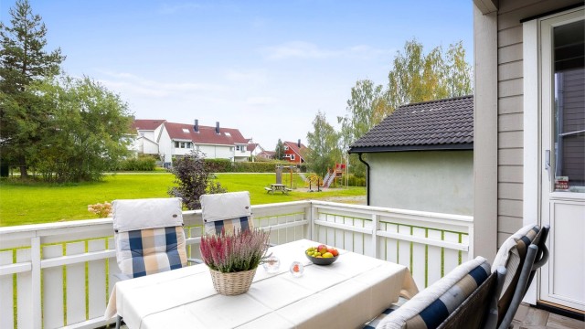 Utsyn fra terrassen mot borettslagets lekeplass og fellesplen.