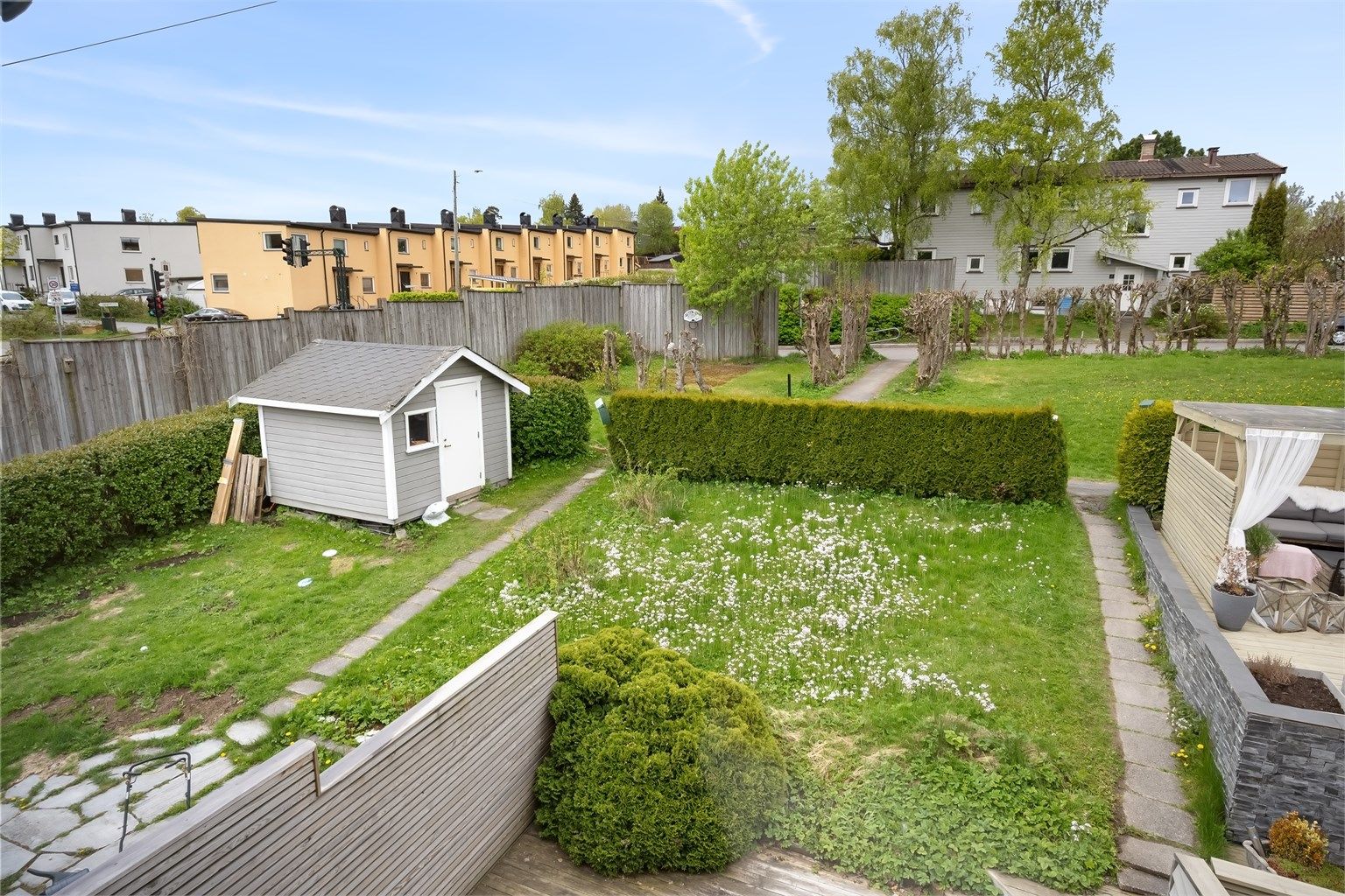 Utsikt fra soveromsvinduet mot fellesarealer og naboeiendommer.