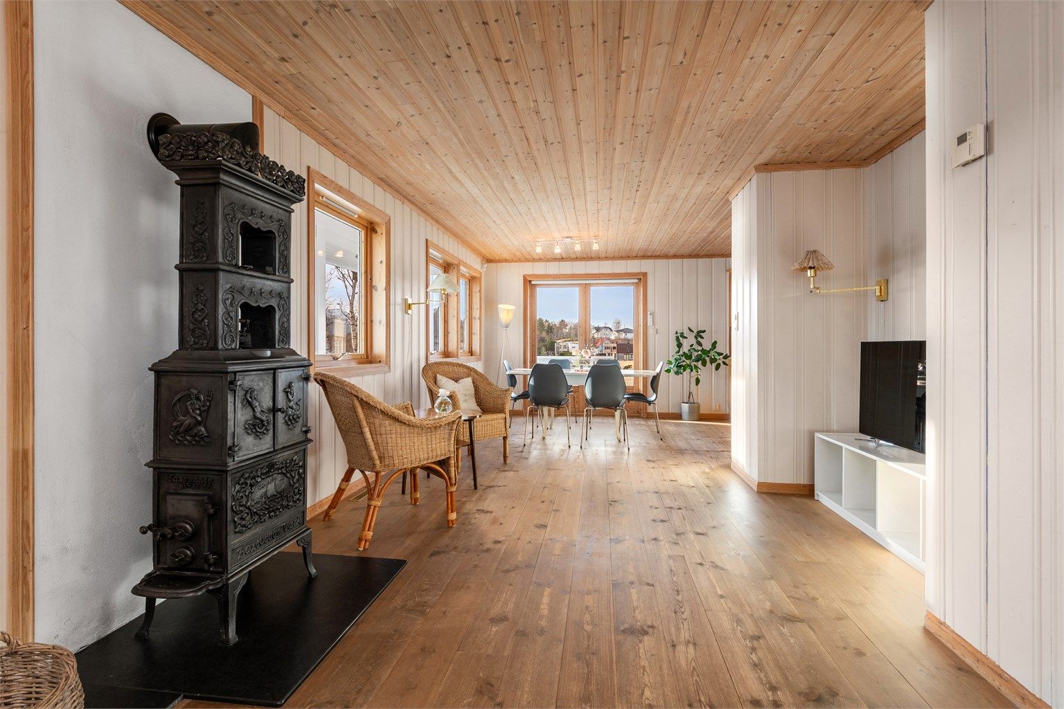 Stor forstue/spisestue og kjøkken i åpen løsning. 
Edre støpejernsovn montert i 2010