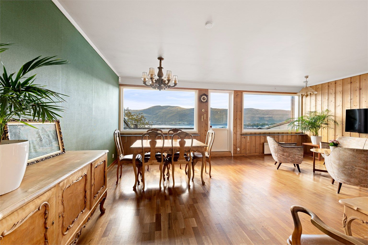 Stue med store vinduer og flott utsikt, samt utgang til veranda