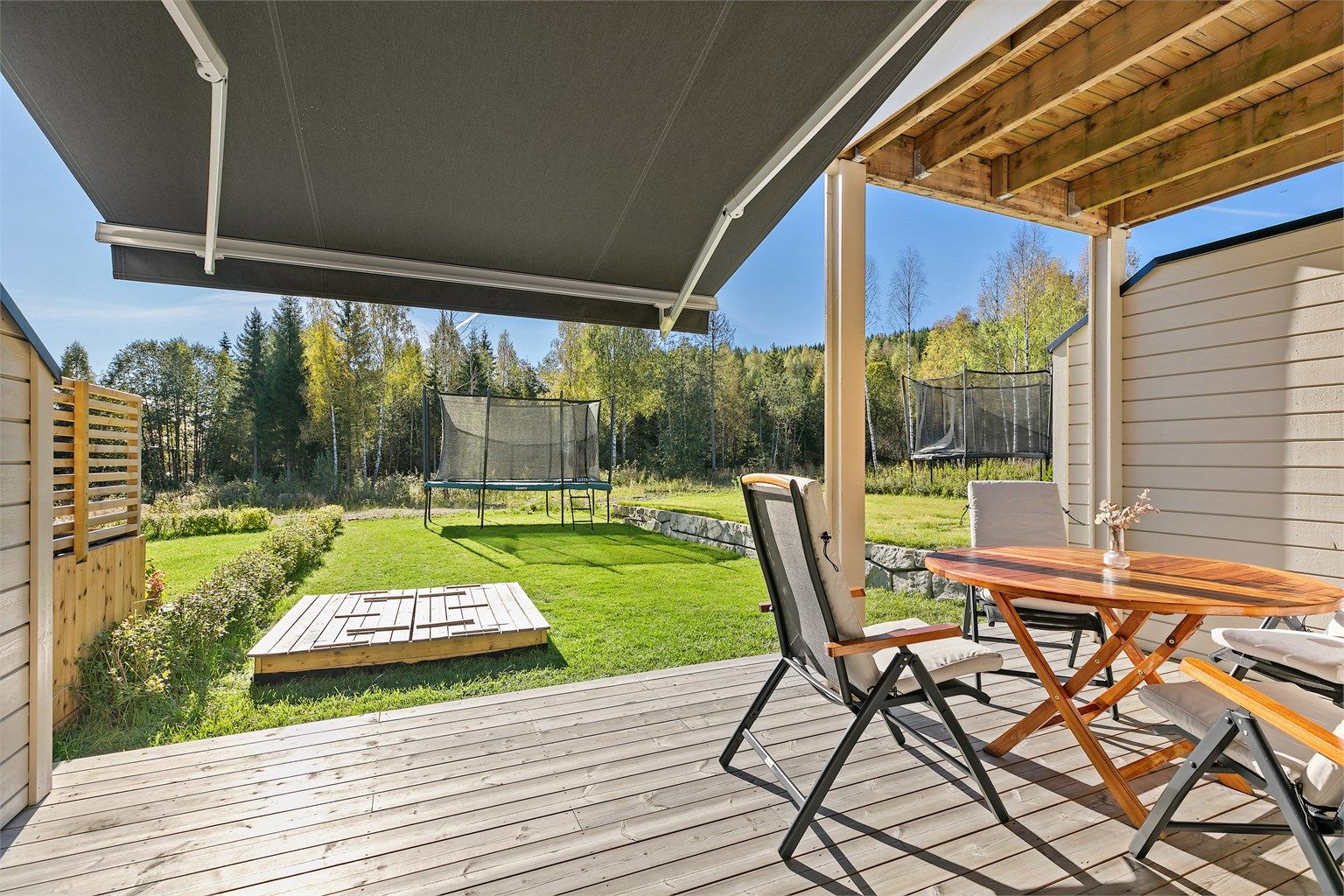 Stor markise er montert av eier over platting for super solskjerming på varme dager. Plass til sittegruppe og f. eks en grill til hyggelige måltider sommerstid.