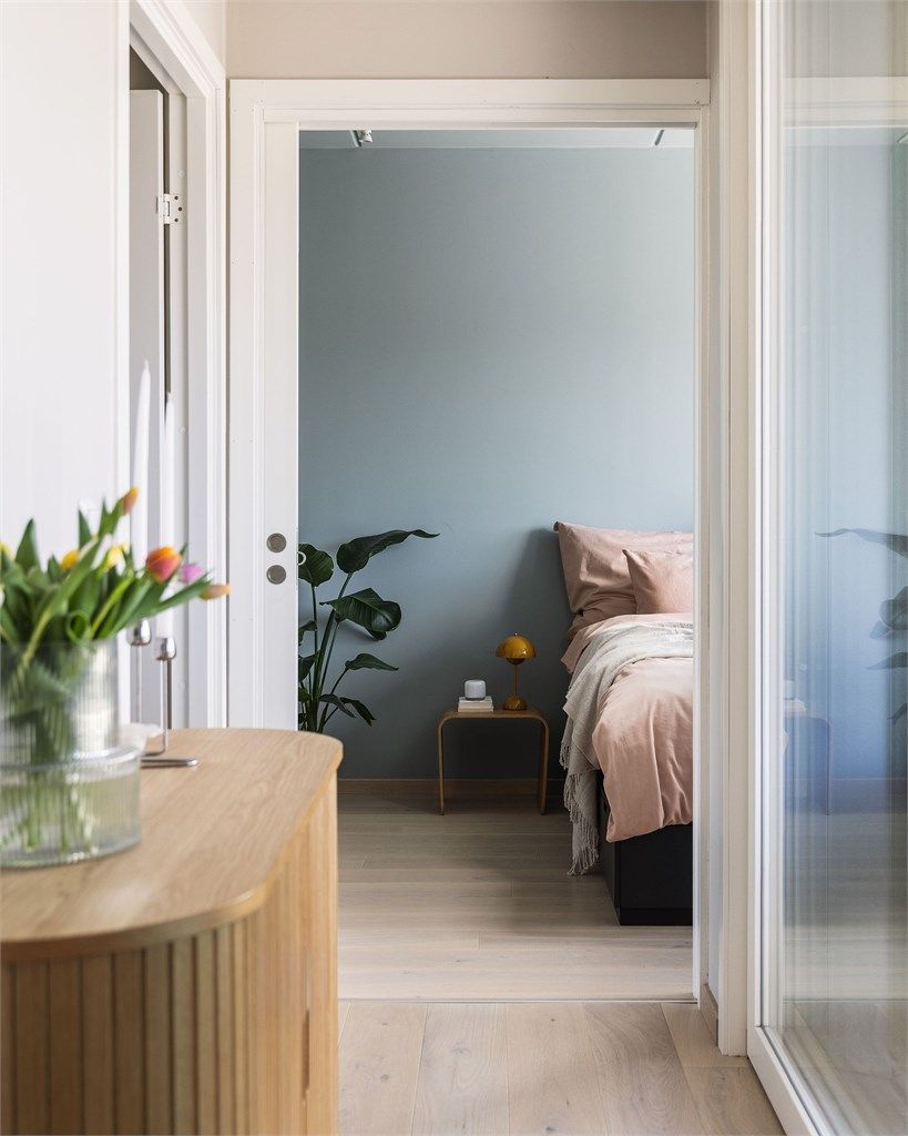 Den store hev- og skyvedøren i glass lar lyset strømme inn fra terrassen og gir gangen et luftig og innbydende preg.