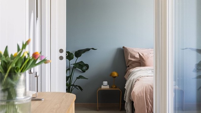 Den store hev- og skyvedøren i glass lar lyset strømme inn fra terrassen og gir gangen et luftig og innbydende preg.
