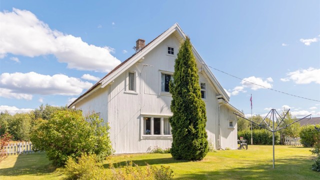 Eiendommen ligger på en tilnærmet flat tomt, opparbeidet med plen og beplantning.