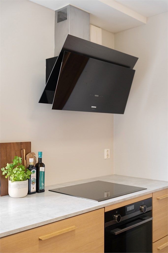 Kjøkkenventilator med kullfilter over platetoppen.