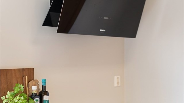 Kjøkkenventilator med kullfilter over platetoppen.