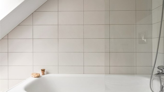 Videre har rommet et behagelig innbygd badekar med innfellbar glassvegg.