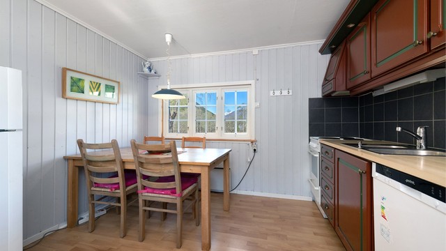 Her er det plass til et spisebord, og kjøkkenet er utstyrt med komfyr og oppvaskmaskin.