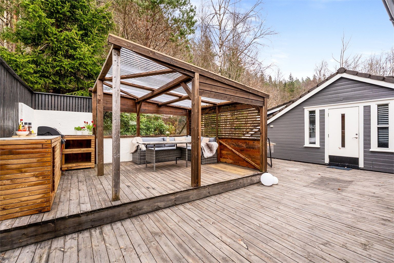 Boligen har en flott usjenert uteplass på baksiden av huset, skjermet for innsyn og med adgang til loftet på garasjen. Foto: Hans Nøstdahl