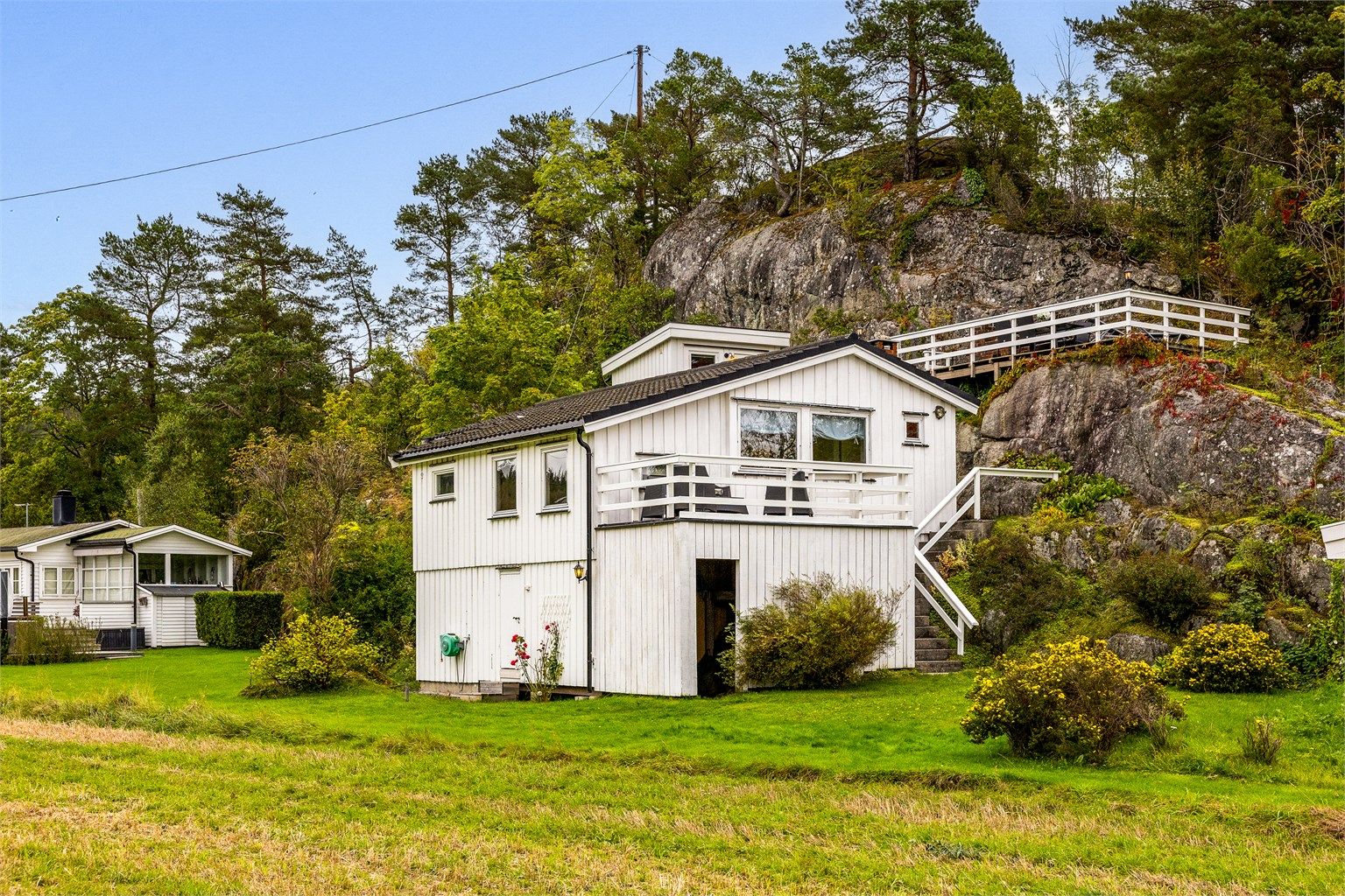 Hytta ligger idyllisk til, Usjenert, midt i det grønne og ved vannet.