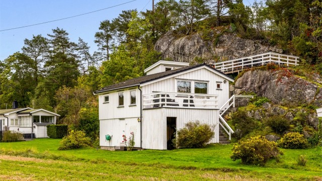 Hytta ligger idyllisk til, Usjenert, midt i det grønne og ved vannet.