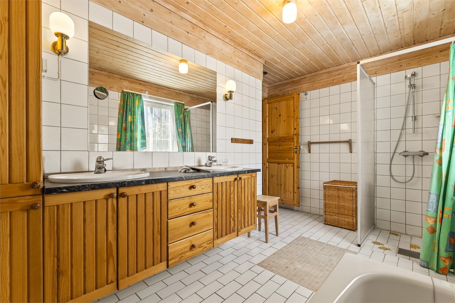 Hovedbadet i andre etasje er flislagt og har gulvvarme. Innredningen har to servanter, perfekt for en travel morgen.
