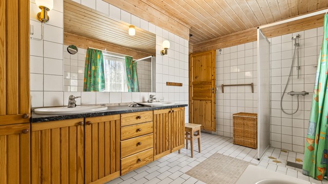 Hovedbadet i andre etasje er flislagt og har gulvvarme. Innredningen har to servanter, perfekt for en travel morgen.