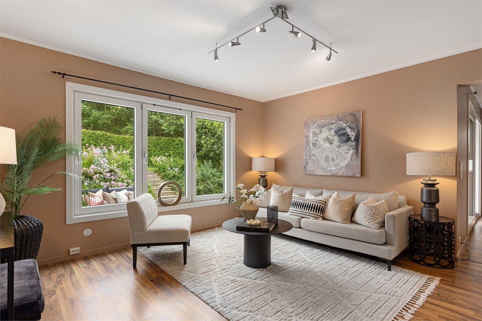 Boligen er malt i varme og delikate farger, som i sammenheng med mye naturlig lys gjennom de store vindusflatene gir en god atmosfære til rommet