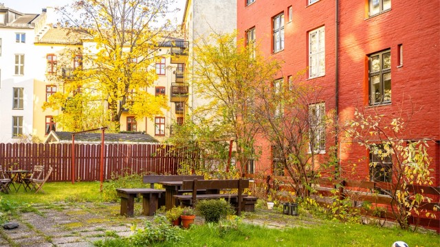 Hyggelig bakgård som er opparbeidet med diverse beplantning, prydbusker og steinbelagte gangbaner.