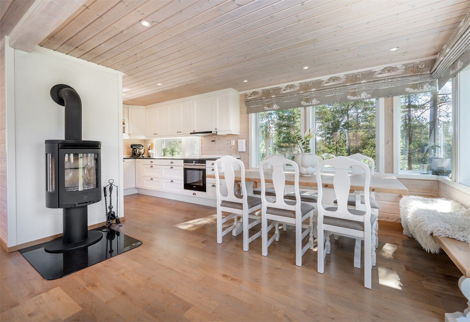 Peisovn med glassdør mellom stue og kjøkken som gir en lun og hyggelig atmosfære