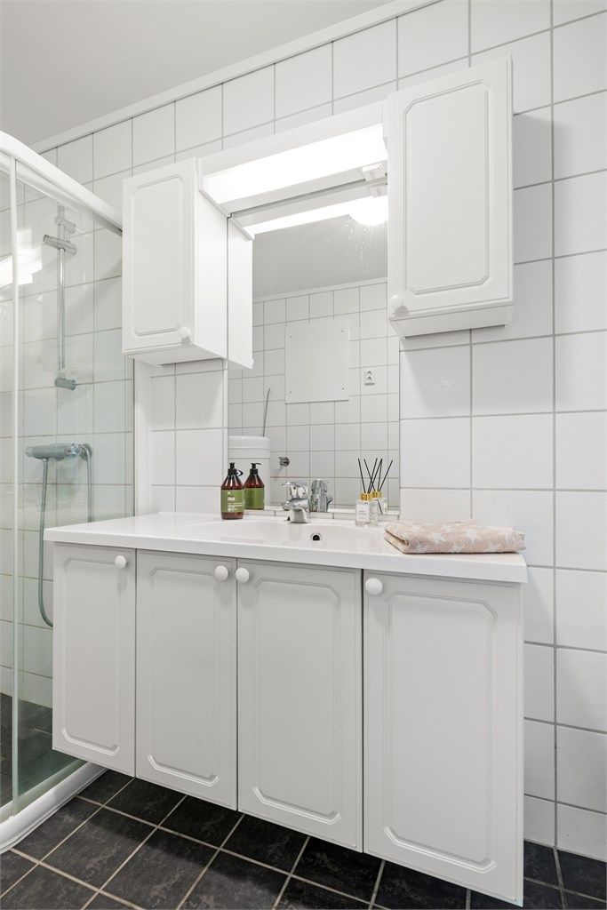 Badet har vegghengt servantinnredning, speil med overlys og stikkontakt.