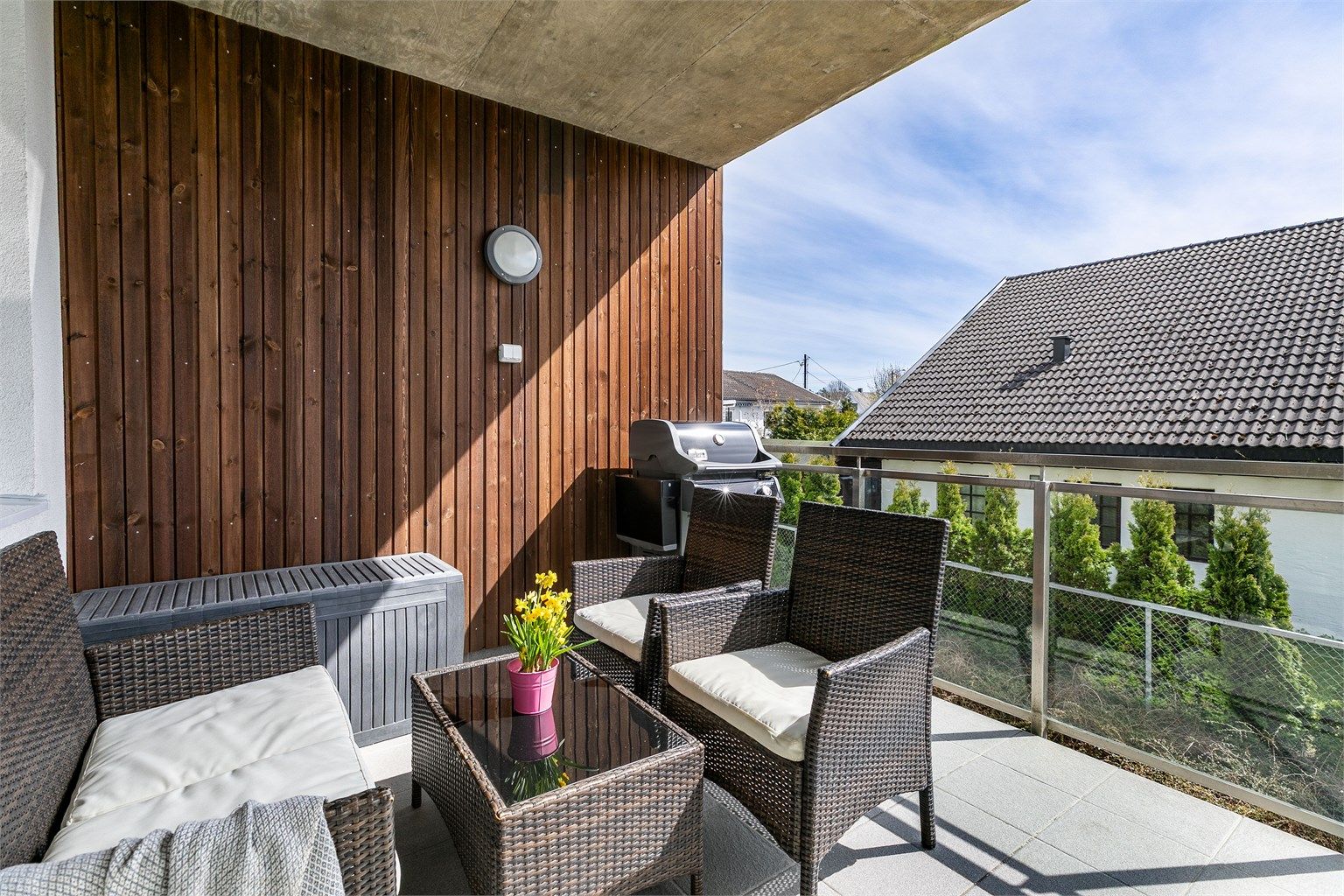 Mens overbygget gjør verandaen skjermet og lun, sørger rekkverkets glass for å slippe solen gjennom.