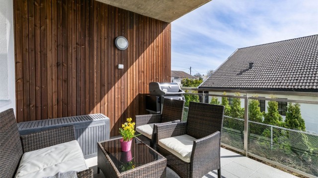 Mens overbygget gjør verandaen skjermet og lun, sørger rekkverkets glass for å slippe solen gjennom.