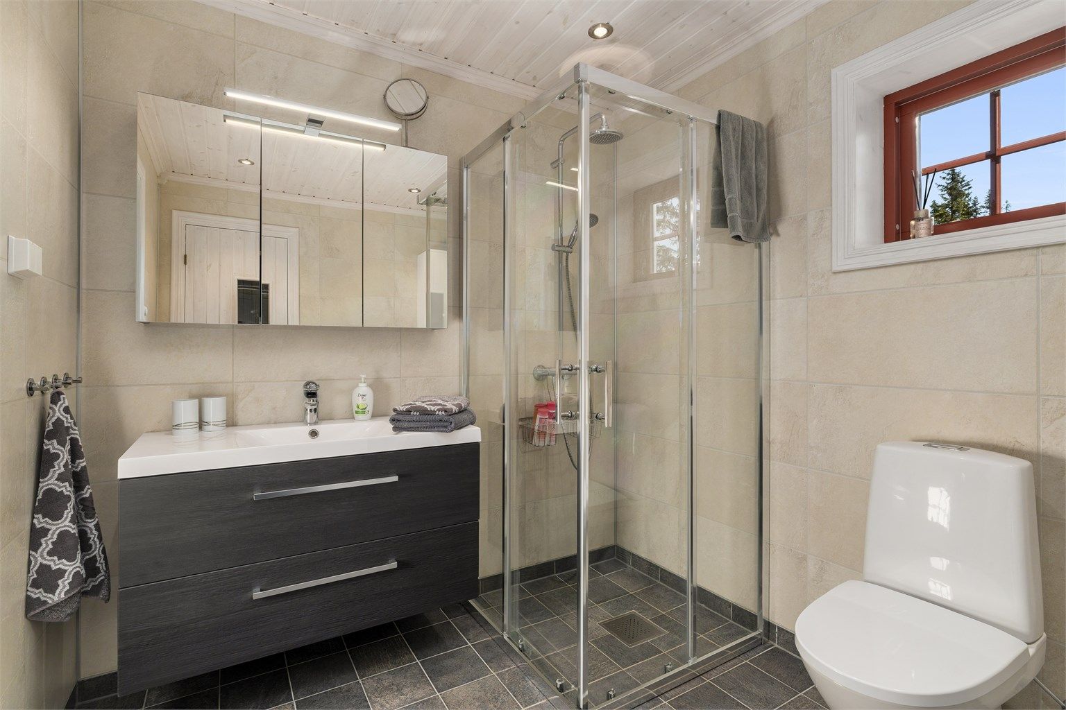 Badet i tilbygget har en mer moderne standard med lyse flater og badstue. 