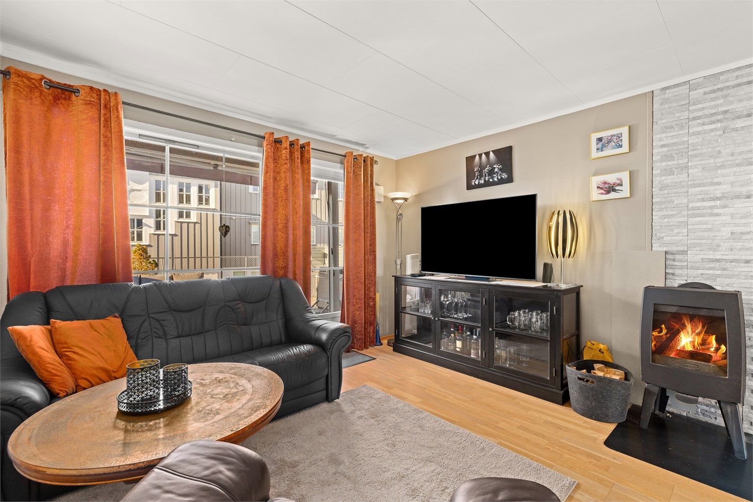 Stuen har en peisovn med glassdør som gir god varme og en hyggelig atmosfære.