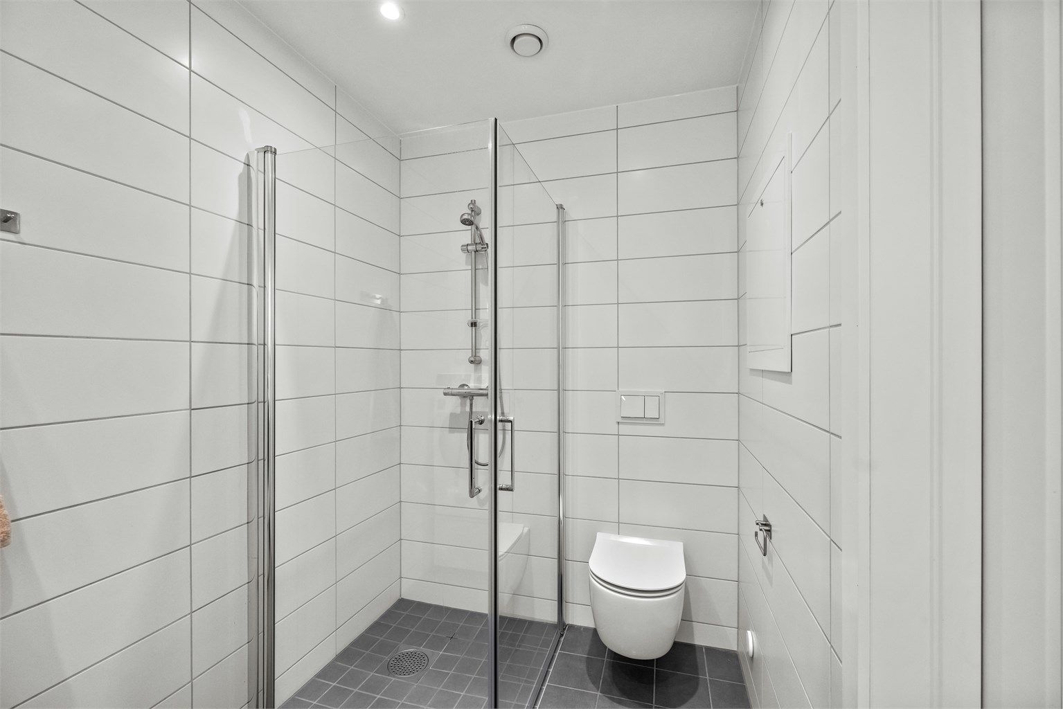 Dusjhjørne med innfellbare glassdører på badet i første etasje.