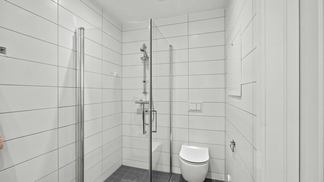 Dusjhjørne med innfellbare glassdører på badet i første etasje.