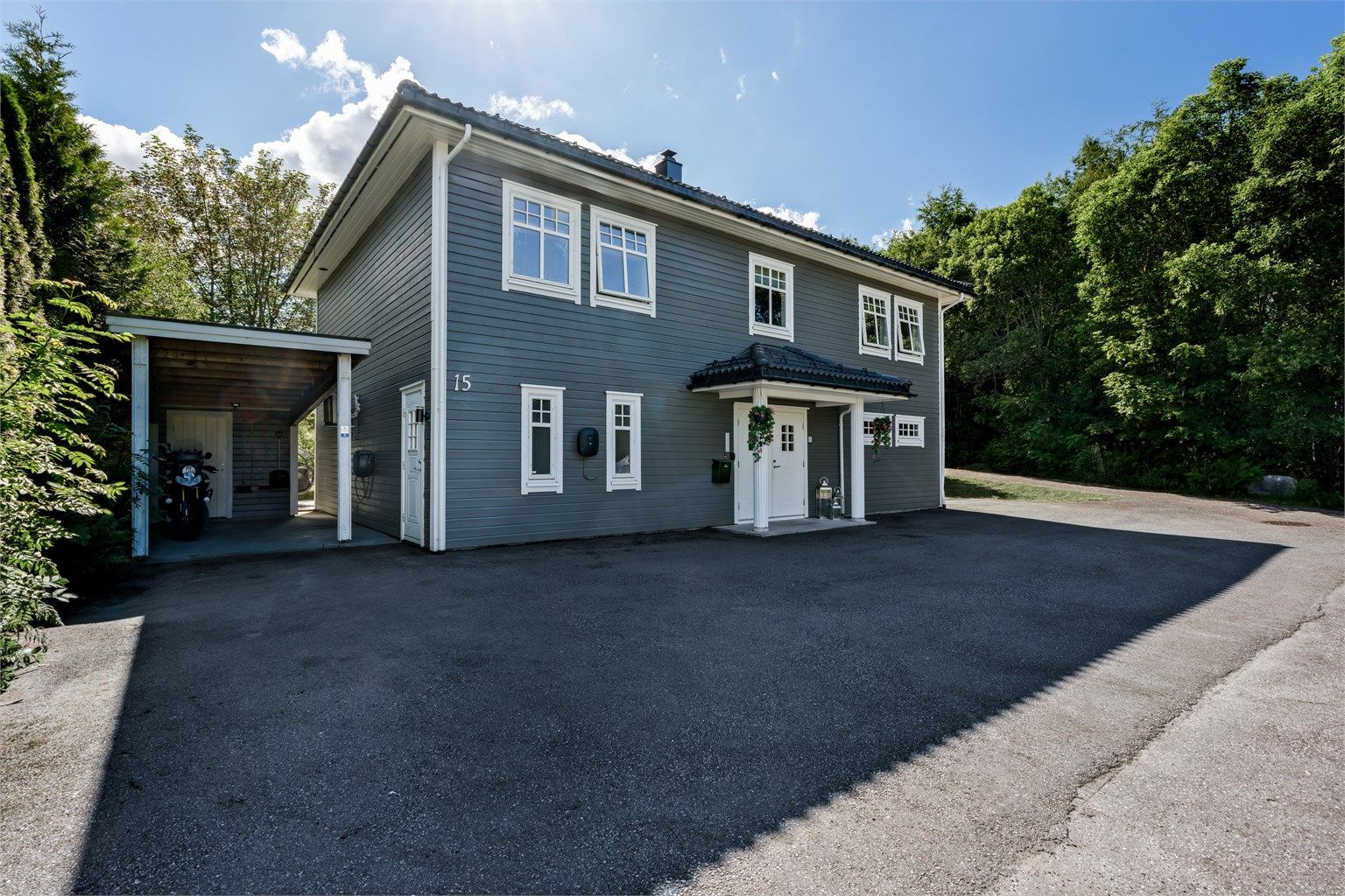 Praktisk carport med tilhørende bod for ekstra lagring.