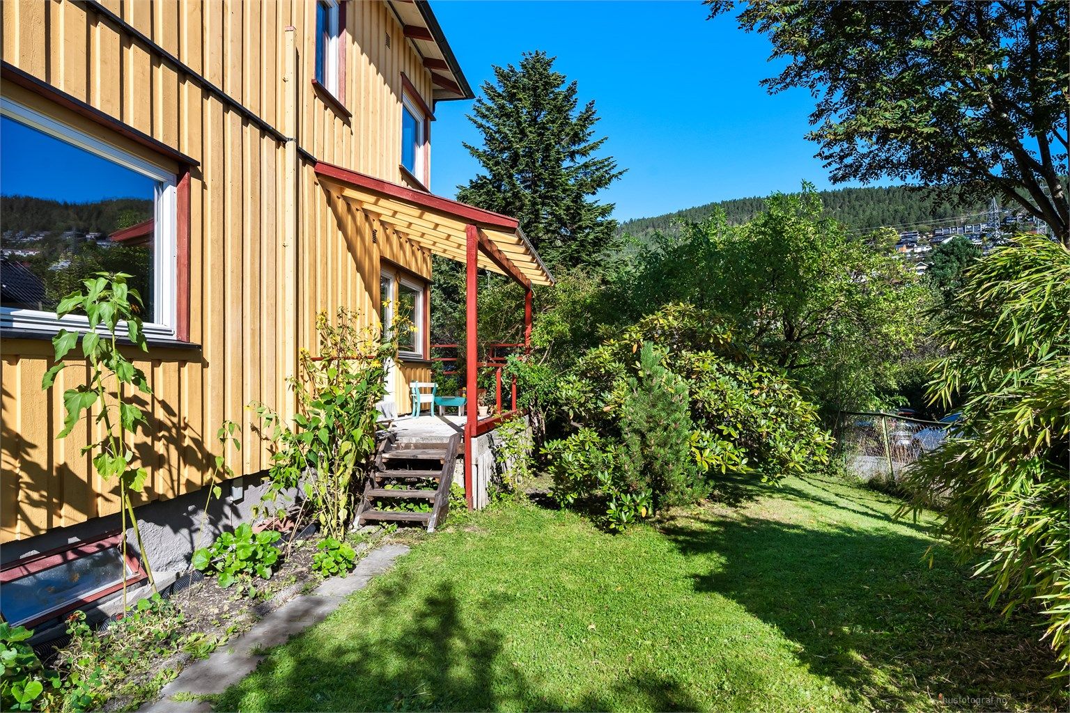 Hageområdet består av flotte prydbusker, trær, flere blomsterbed, gressplen og diverse beplantninger
