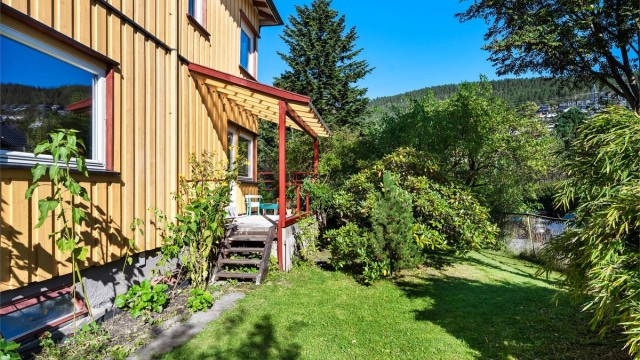 Hageområdet består av flotte prydbusker, trær, flere blomsterbed, gressplen og diverse beplantninger