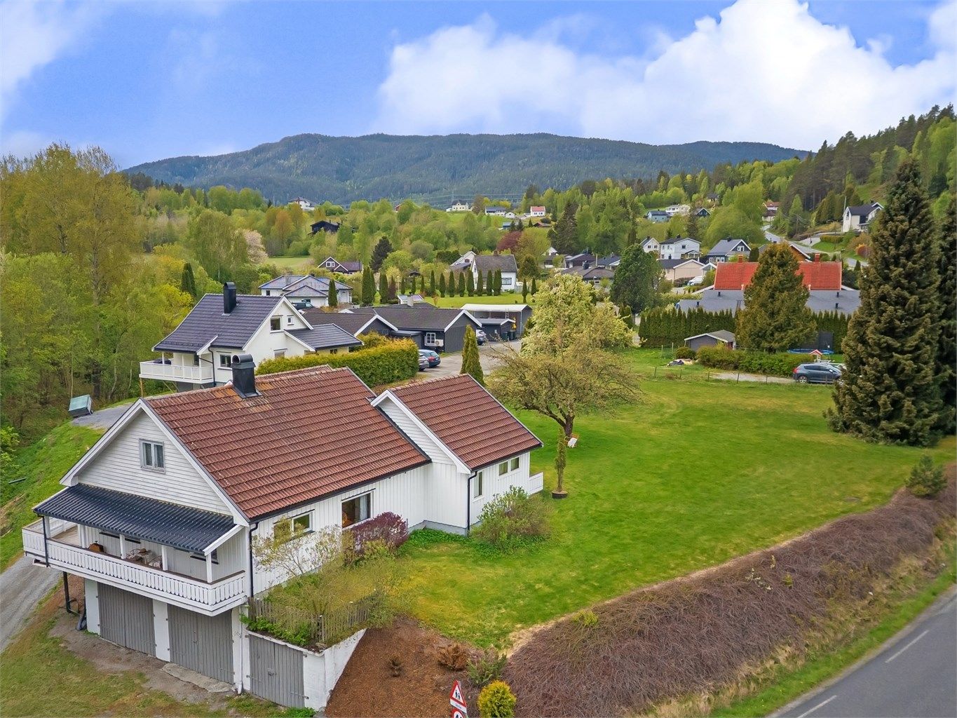 Bingsveien 39 - Enebolig med store garasje i kjeller (ca 3 meter høyde på to av tre plasser) og uthus/sidebygning. I tillegg følger Hellerudveien 19 - boligtomt på ca 2,7 mål som grenser til eiendommen. Foto: Emotional Landscape Production Ole Thoresen