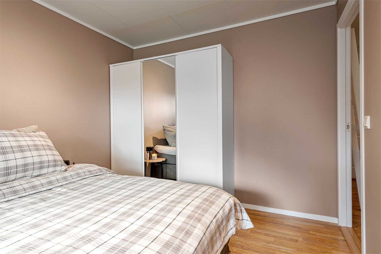 En stor skyvedørsgarderobe med tre fronter gir rikelig med oppbevaringsplass.