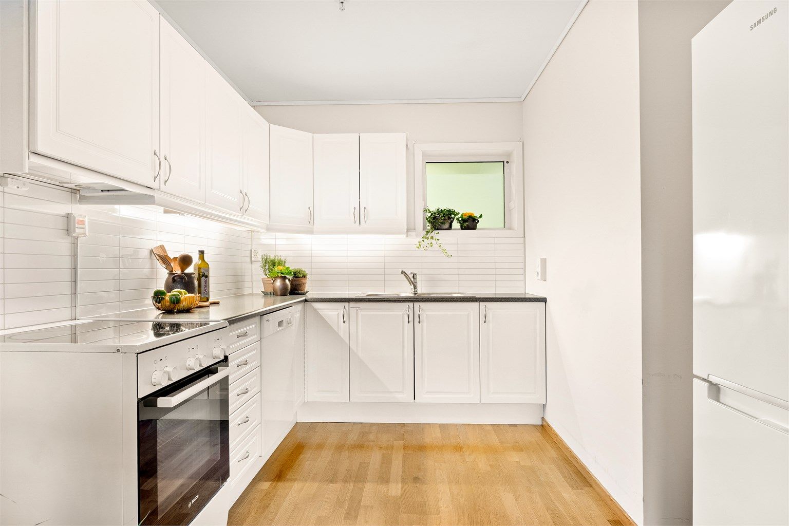 Kjøkkenet er lyst med  tradisjonelle profiler på frontene. Kjøleskap medfølger ikke! 