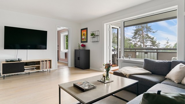 Stor og lys stue med utsyn og utgang til balkong. Enkelt å møblere med god plass til både sofagrupper og stort spisebord