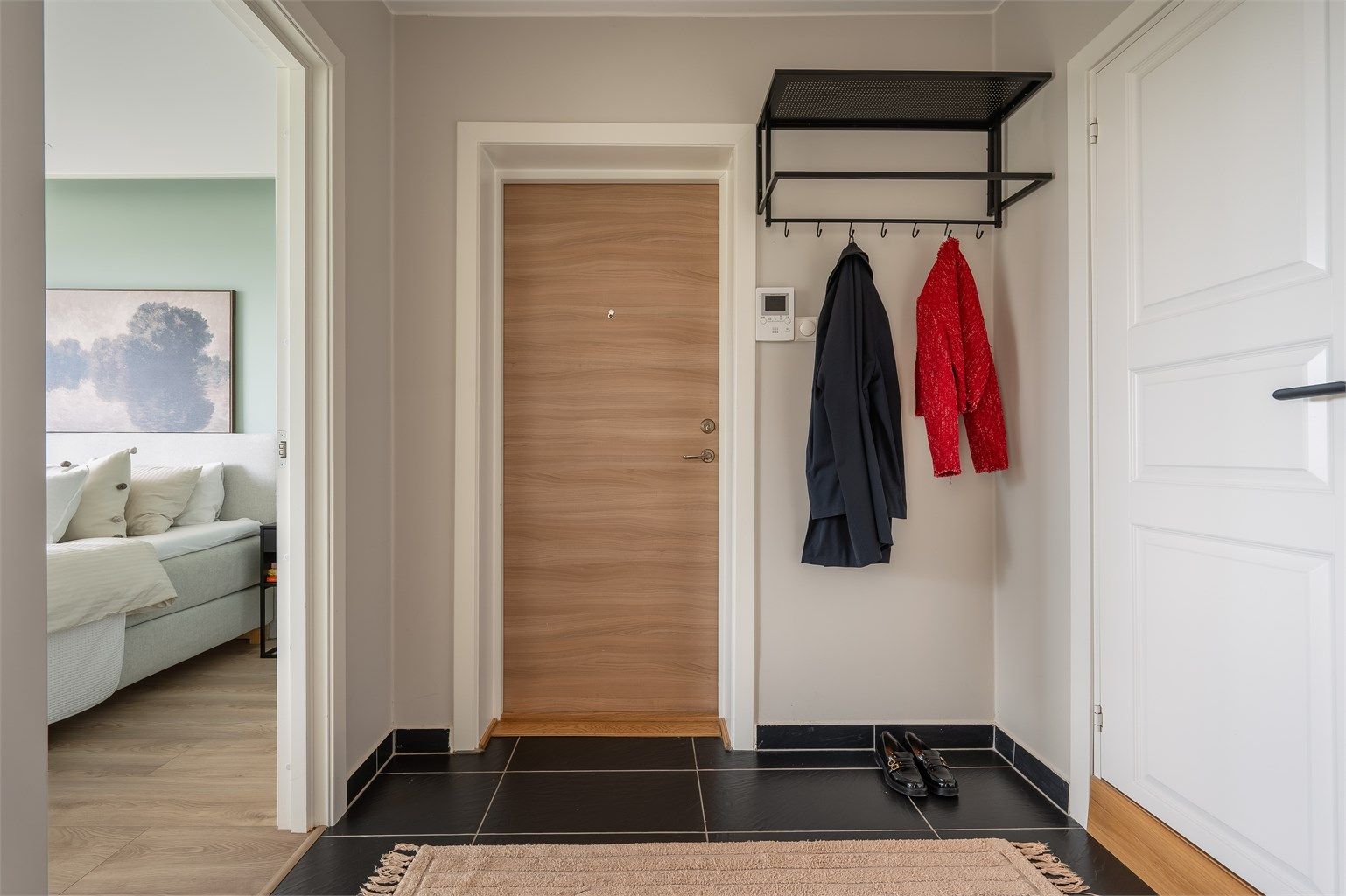 Entré med flislagt gulv og plass til yttertøy og sko
