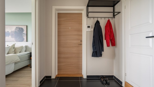 Entré med flislagt gulv og plass til yttertøy og sko